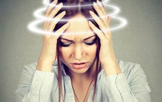 woman holding her head suffering from dizziness and vertigo