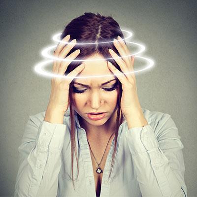 woman holding her head suffering from dizziness and vertigo