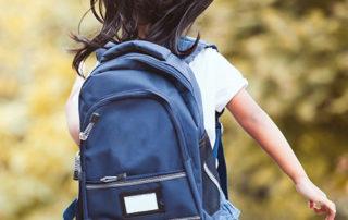 young child with backpack going to school