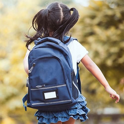 young child with backpack going to school