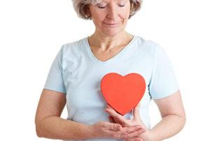 Woman holding paper heart for heart health